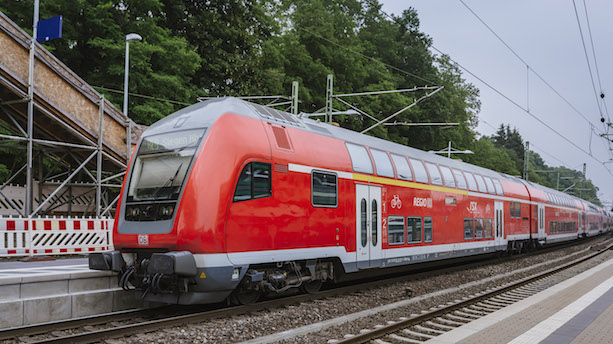 Ein roter Doppelstockzugwagen des Typs DABpbzfa 765.5 an einem Bahnsteig.