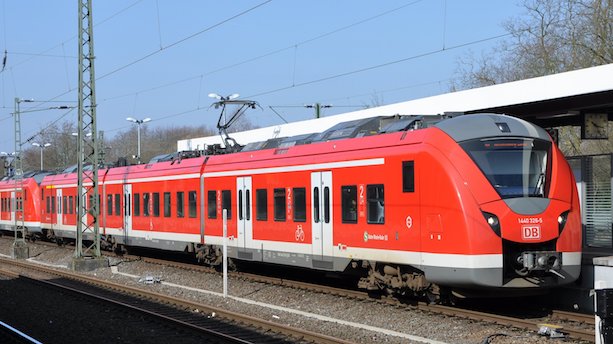 Ein rot-weißer Zug des Typs BR1440 Coradia Continental steht an einem Bahnsteig.