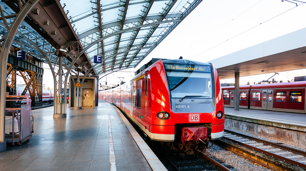 Ein rot-weißer Zug vom Typ BR425 mit Fahrtziel Düsseldorf Hauptbahnhof steht an einem Bahnsteig.