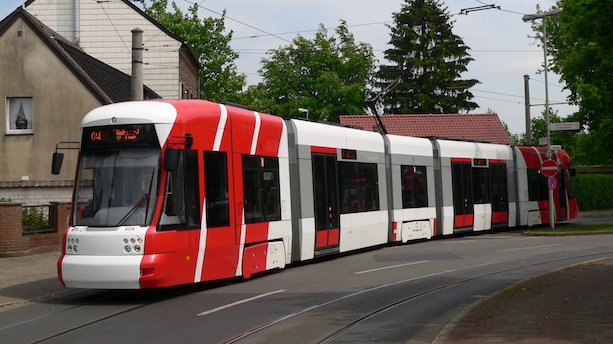 Ein rot-weißer Niederflurstraßenbahnwagen des Typs Cityrunner fährt über Straßenbahngleise.