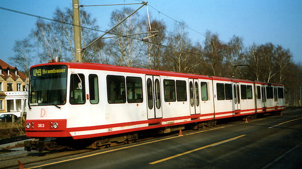 Ein weiß-roter Stadtbahnwagen vom B80C8 fährt Straßenschienen entlang.