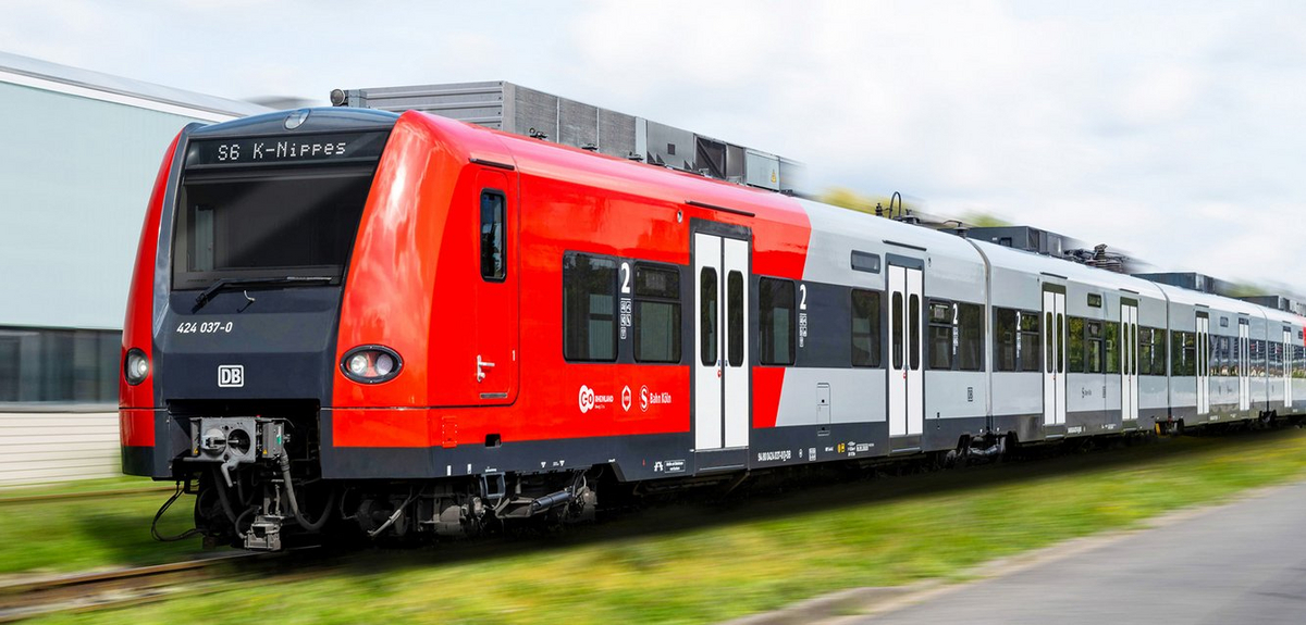 Ein roter-grauer S-Bahn-Triebwagen vom Typ BR424 fährt.