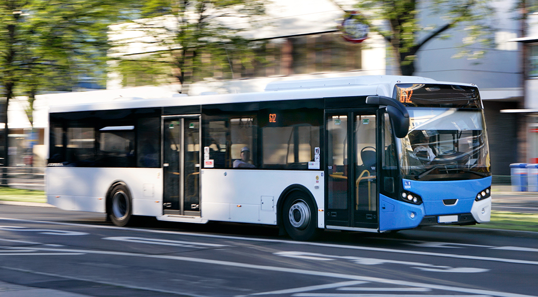 Ein weiß-blauer Stadtbus fährt über eine Straße