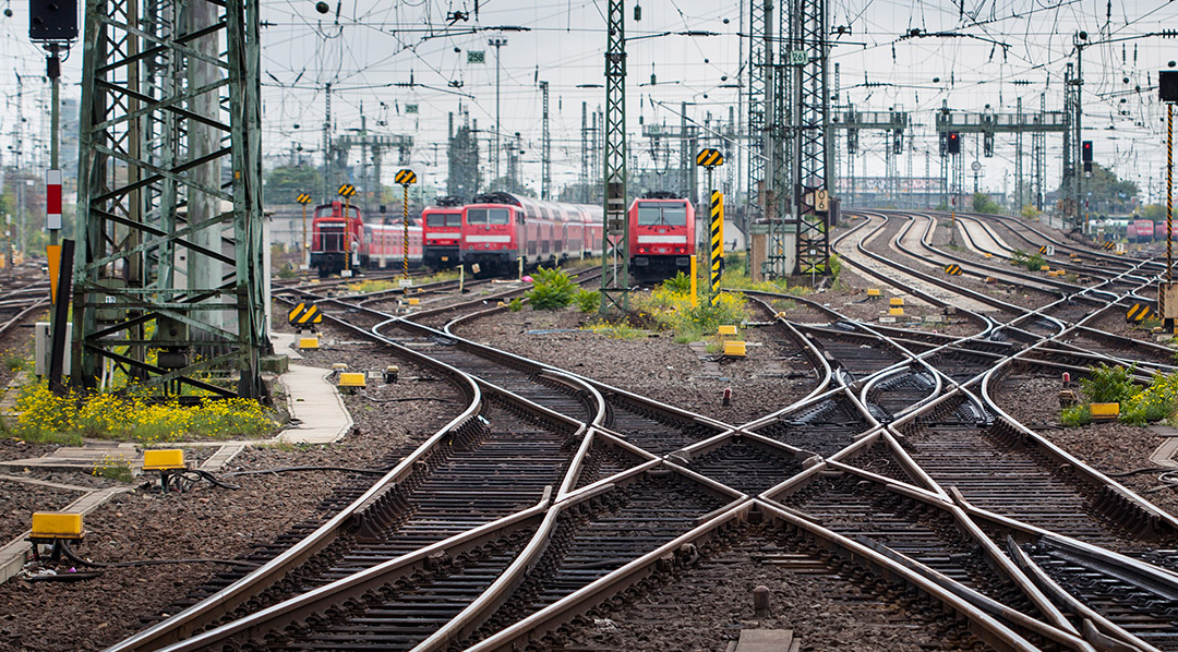 Weiltäufiges Schienennetz mit vielen Oberleitungen und eingen Zügen.