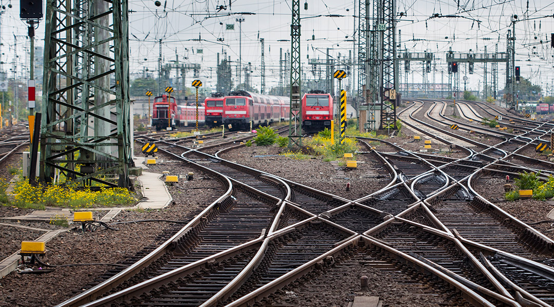 Weiltäufiges Schienennetz mit vielen Oberleitungen und eingen Zügen.