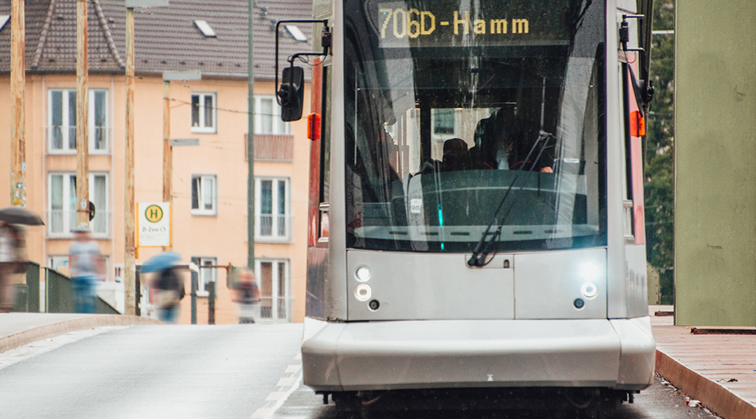 Frontalaufnahme einer silbernen Straßenbahn, die über eine Brücke fährt und das Fahrtziel Hamm anzeigt.